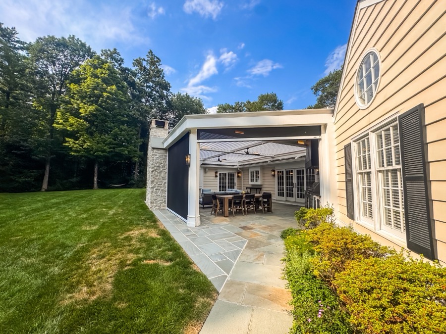 Covered outdoor living space with integrated screens down for shade and privacy