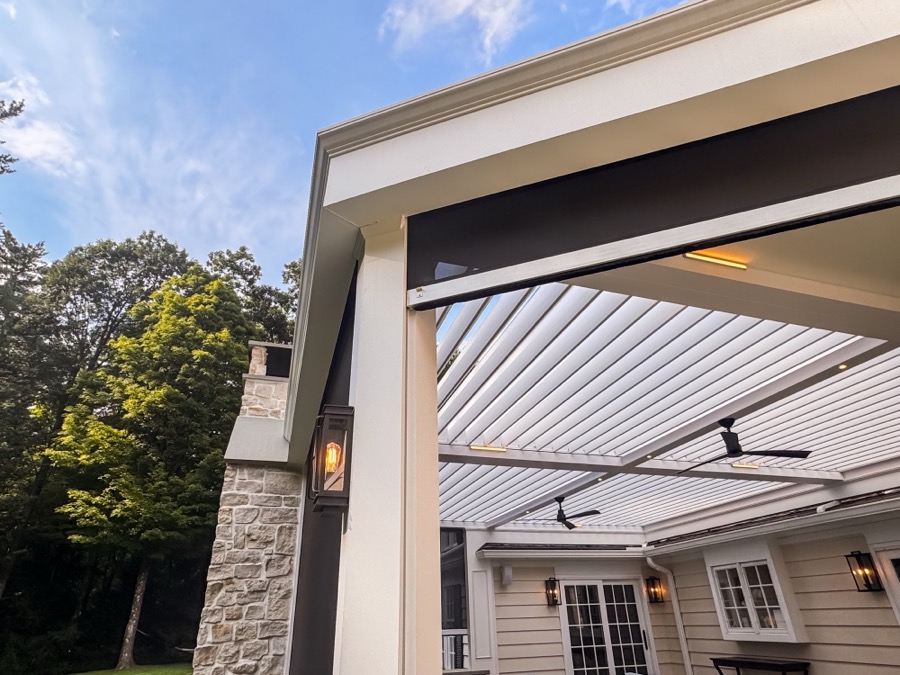 Louvered roof pergola interior with motorized screens lowered at dusk
