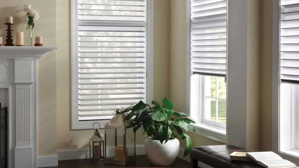 Bright living room featuring Hunter Douglas window shades, neutral walls, a fireplace, and a potted plant near large windows.