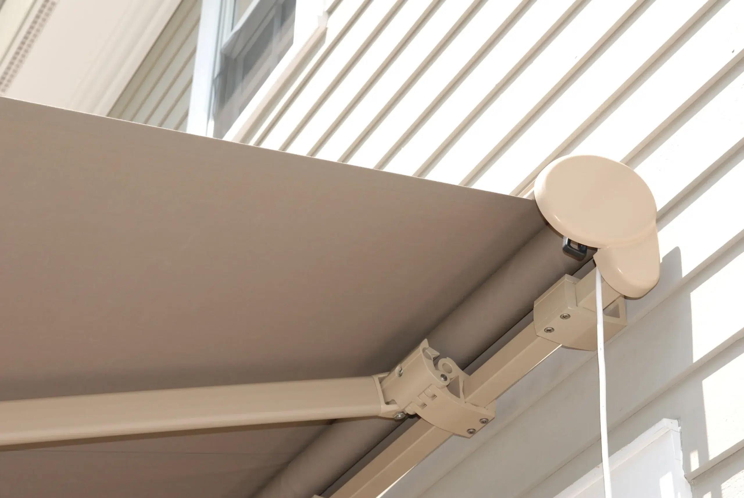 House featuring a retractable awning extending over a back porch, perfect for enjoying outdoor spaces.