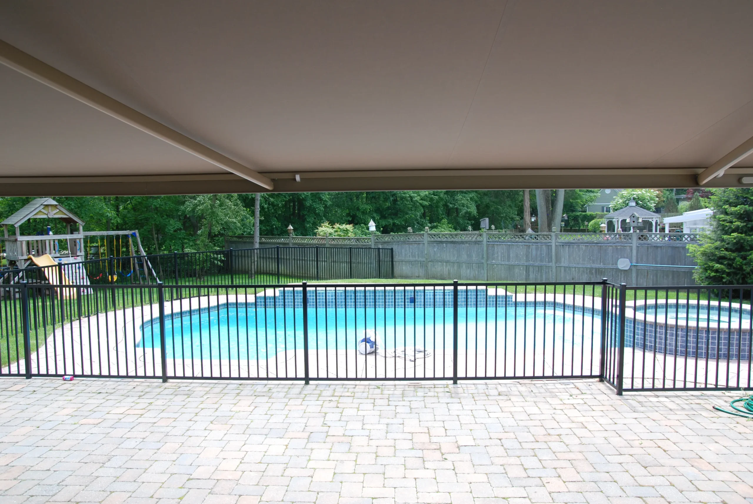 A charming house with a retractable awning installed above the front porch for added shade and comfort.