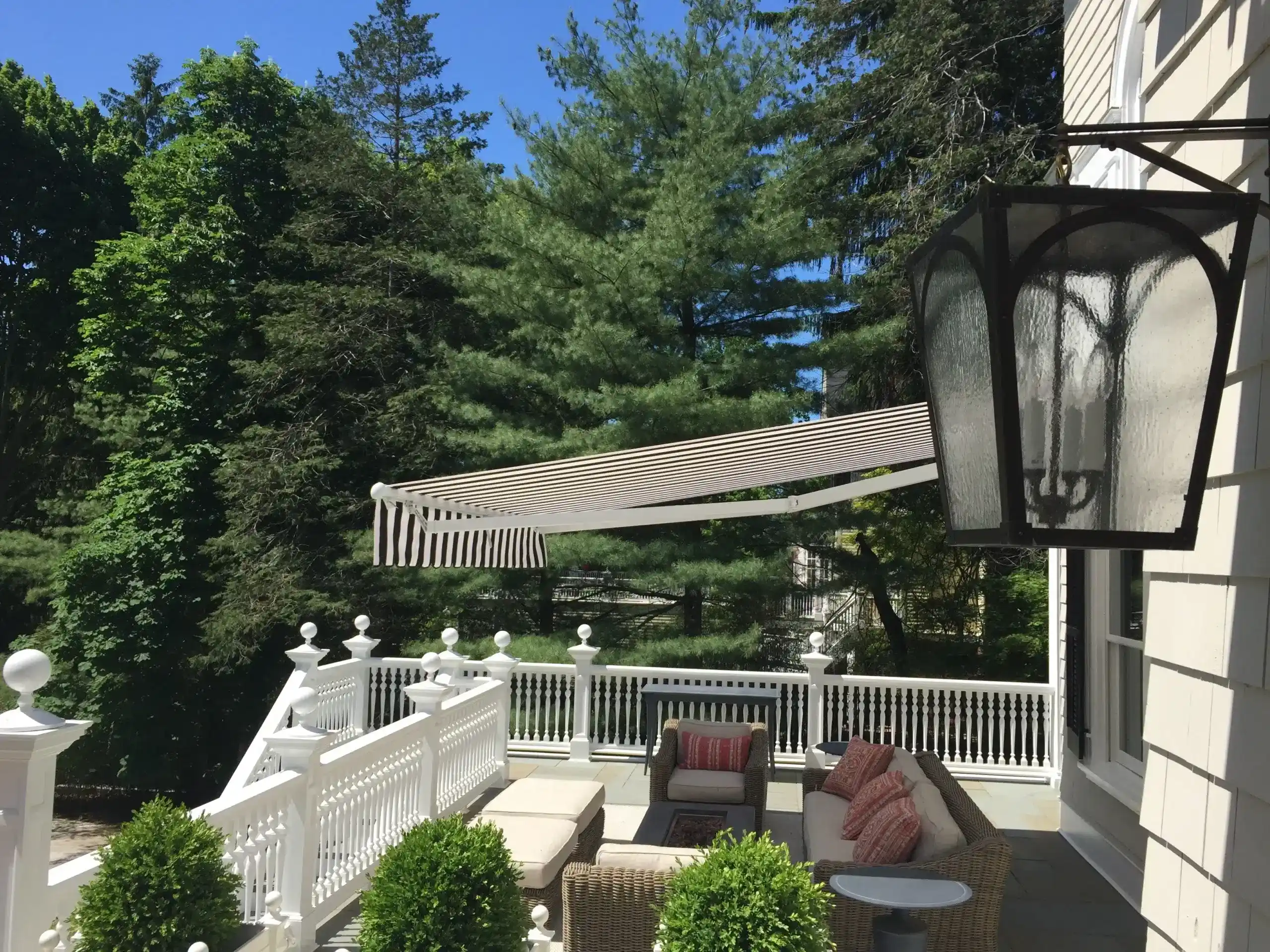Retractable awning extended over a patio with seating, providing shade and protection from the elements.